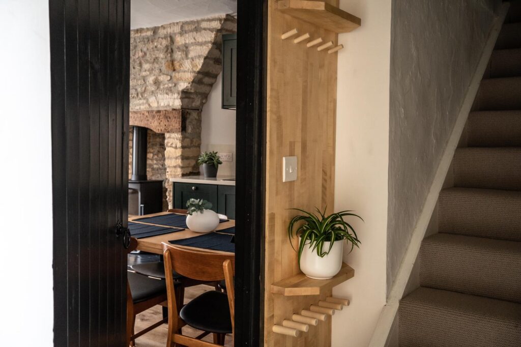 Hallway and staircase at Marble Arch in Wiltshire, with a view into the kitchen diner
