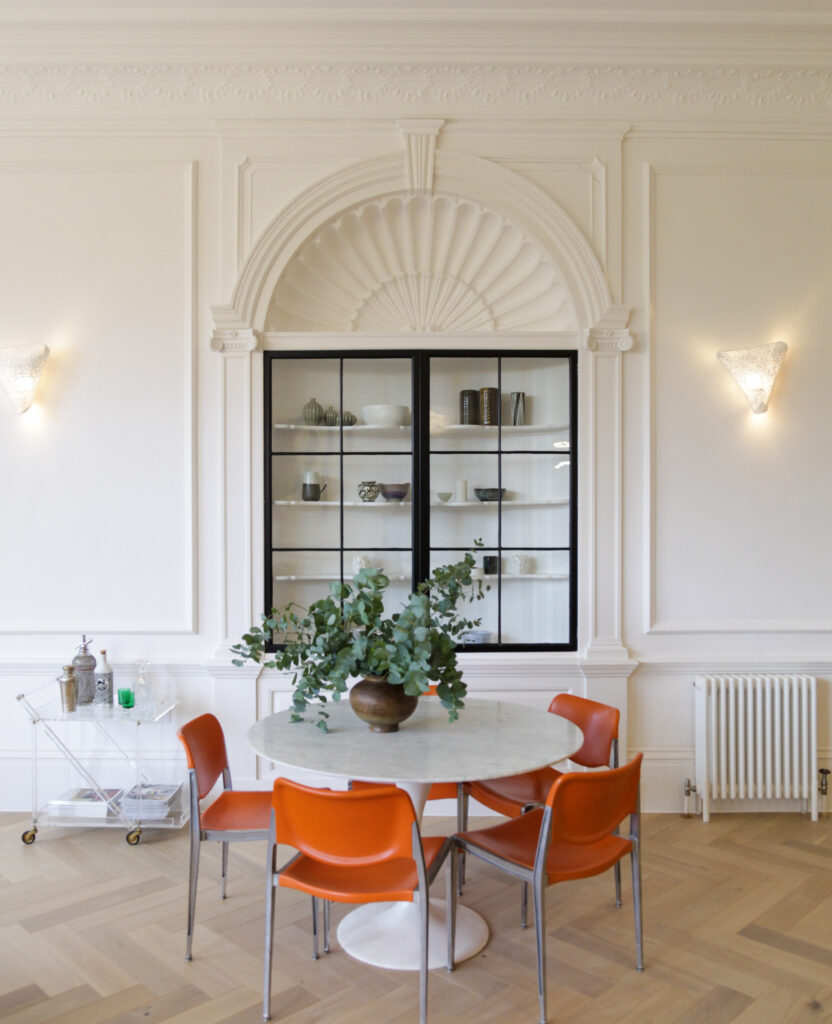Interior with a dining table and orange chairs at The Priory in Tetbury, Cotswolds